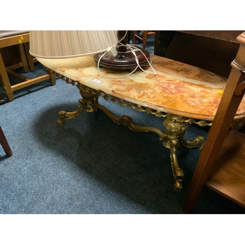 869 - An oval onyx coffee table together with a mahogany standard lamp and shade