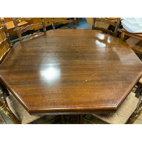 888 - A carved Edwardian oak octagonal table together with six later ladderback wicker seat chairs Table D... 