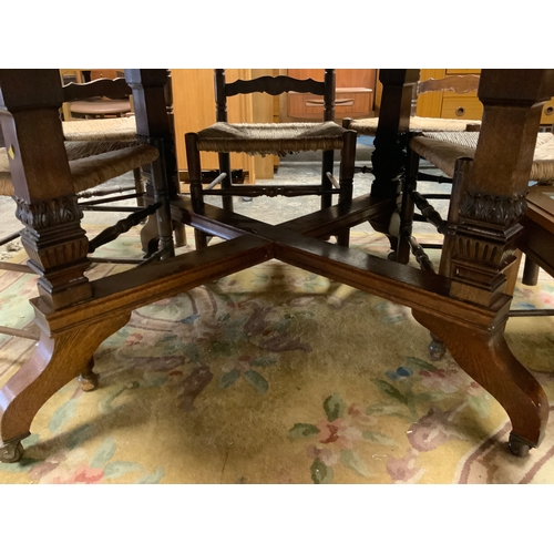 888 - A carved Edwardian oak octagonal table together with six later ladderback wicker seat chairs Table D... 