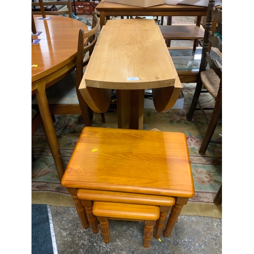 889 - A solid light oak drop leaf table together with a pine nest of tables