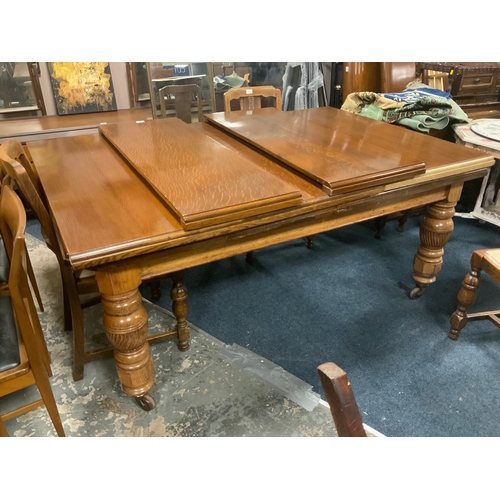 740 - A large oak extending Edwardian dining table with four assorted extra leaves