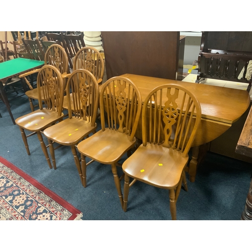 776 - An oak drop leaf table together with six wheel back chairs