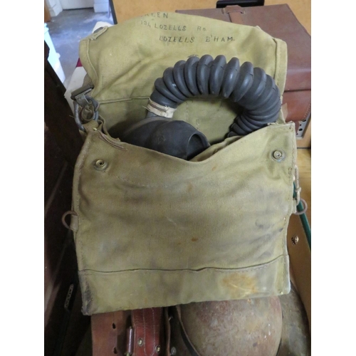 79 - A tray of militaria to include steel helmet, binoculars, WW2 gas mask, Sam Browne belt etc