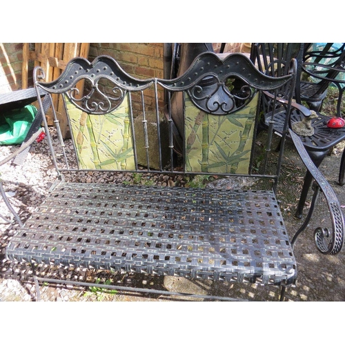 610 - A wrought iron garden set consisting of a table, two chairs and a bench