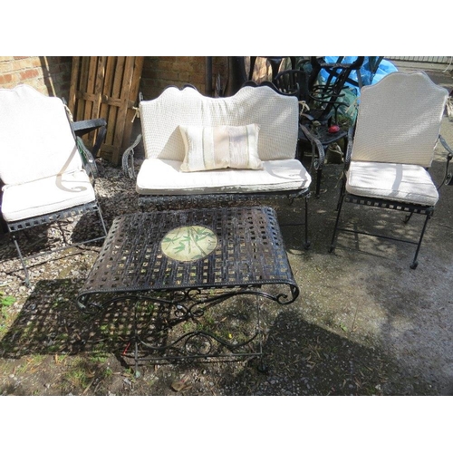 610 - A wrought iron garden set consisting of a table, two chairs and a bench