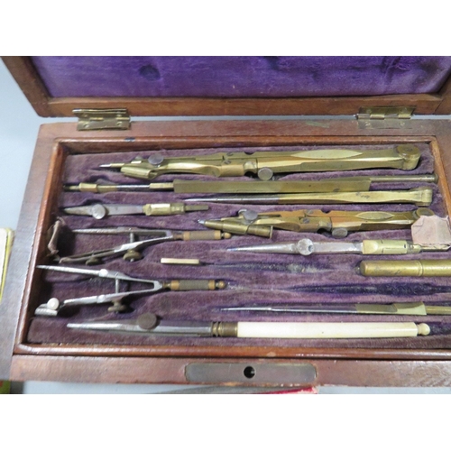 498 - A tray of assorted collectables to include vintage handcuffs, playing cards, cased instrument set, s... 