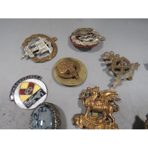 536 - A tray of collectables to include military cap badges , coins etc