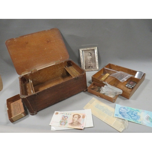 543 - A small quantity of collectables in a wooden box, coins notes and lighters