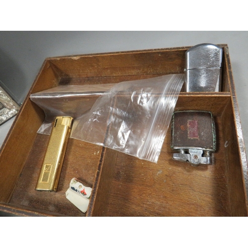 543 - A small quantity of collectables in a wooden box, coins notes and lighters