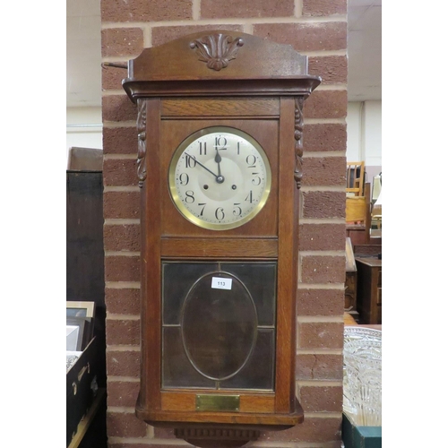 113 - A vintage oak cased clock with key and pendulum