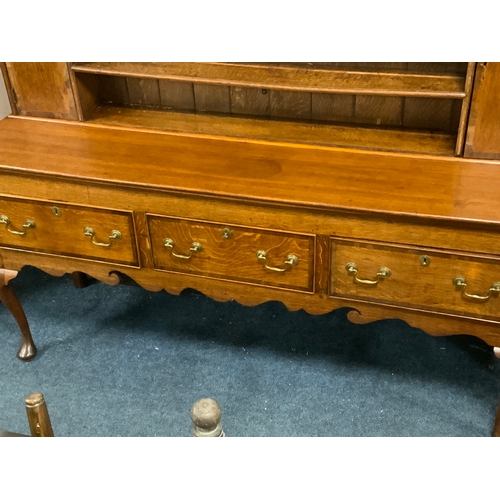 825 - An antique oak and mahogany crossbanded Welsh dresser with three drawers, raised on cabriole legs H ... 