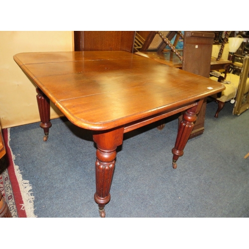 761 - A small Victorian mahogany wind-out dining table raised on fluted supports with a spare leaf - Handl... 