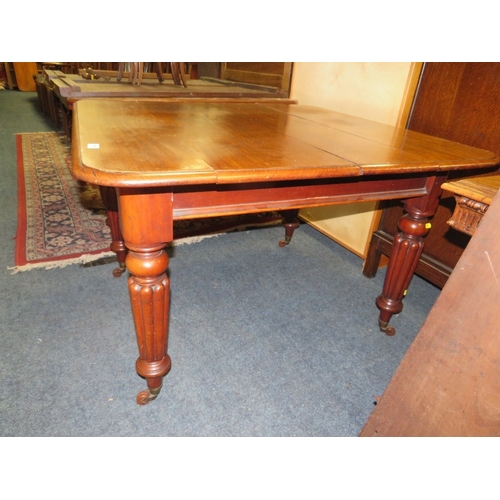 761 - A small Victorian mahogany wind-out dining table raised on fluted supports with a spare leaf - Handl... 