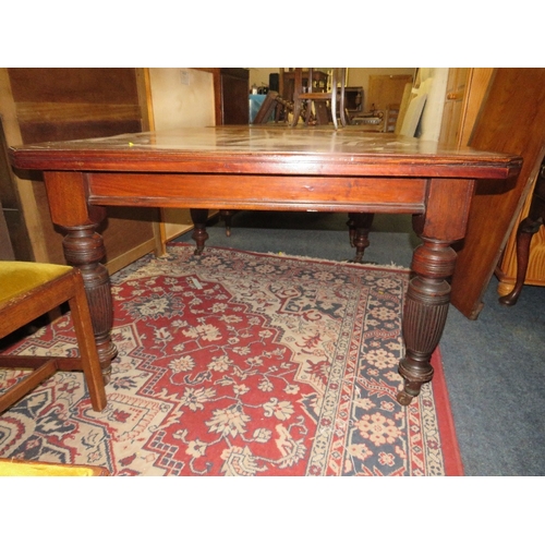 762 - A large Edwardian mahogany wind-out dining table raised on fluted supports with two leaves - Handle