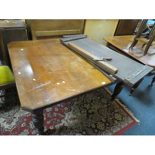 A large Edwardian mahogany wind-out dining table raised on fluted supports with two leaves - Handle