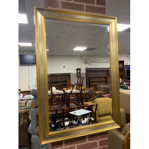 738 - A modern gilt rectangular wall mirror 105 x 75 cm