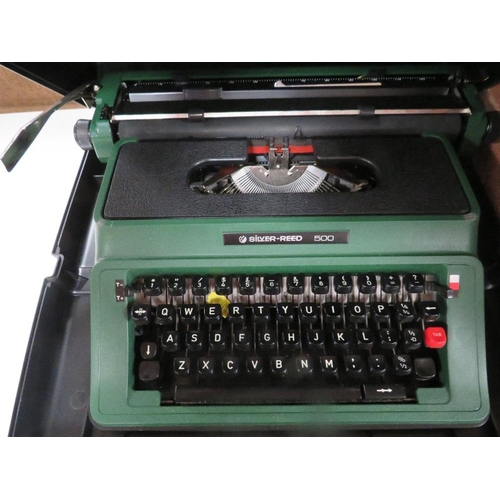 114 - A modern red anglepoise style desk lamp together with two cased typewriters etc