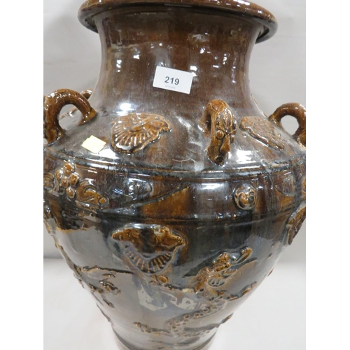 219 - A large treacle glaze Oriental style vase with applied three toed dragon decoration