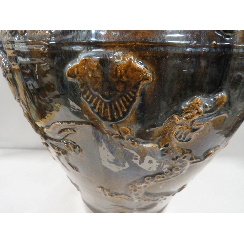 219 - A large treacle glaze Oriental style vase with applied three toed dragon decoration