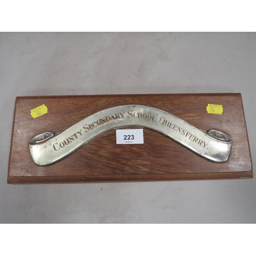 223 - A white metal strip on wooden plaque inscribed 'County Secondary School, Queensferry'