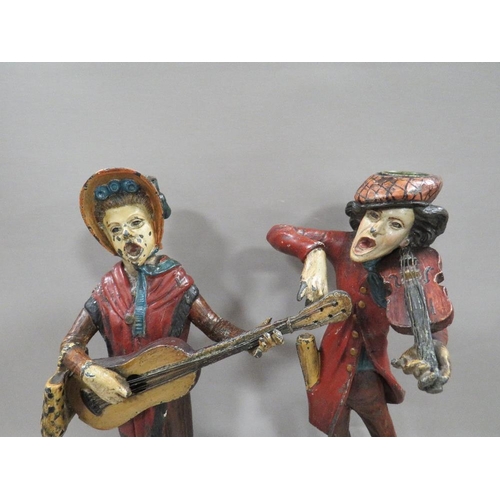 265 - A pair of French cold painted spelter street musicians caricature candlesticks, both signed Francois... 