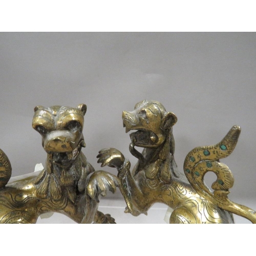 269 - A pair of Oriental brass / bronze guardian dog figures, with green glass inlays