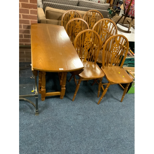 812 - A modern dropleaf table with six wheel back chairs