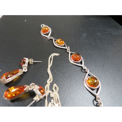 354 - An amber and sterling silver bracelet, pendant on chain and earrings