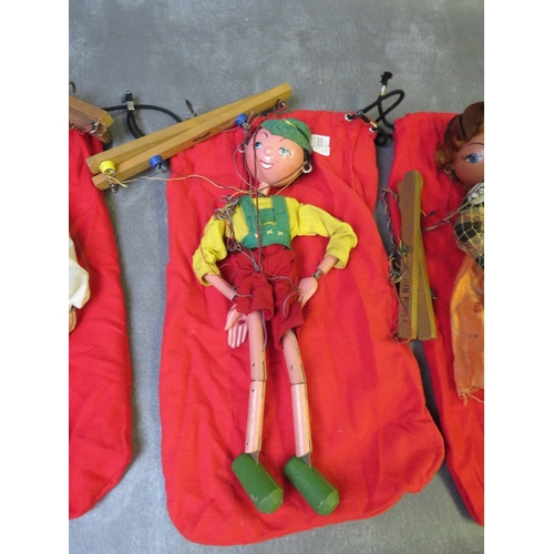 185 - FOUR UNBOXED PELHAM PUPPETS, to include Tyrolean boy / girl and cowboy / girl,  all in red puppet ba... 