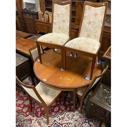 876 - A mid-century teak extending table with six chairs