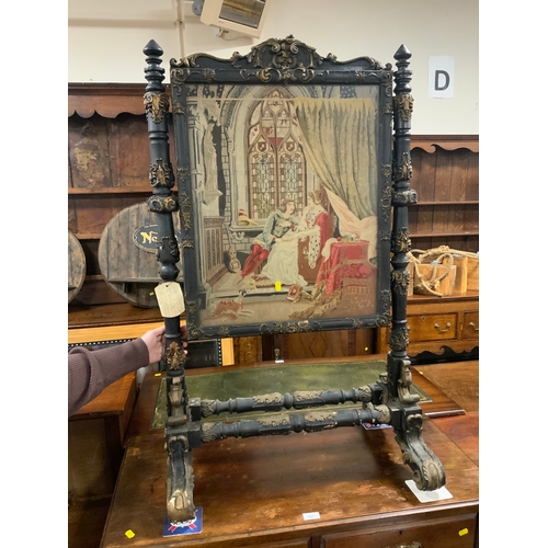 880 - A Victorian carved and gilded revolving fire screen, with two needle point panels depicting flowers ... 