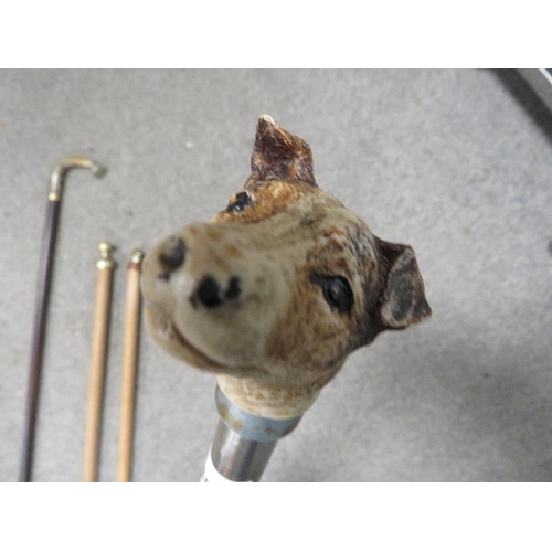 448 - A selection of four walking sticks to include a modern metal one with a Jack Russell head