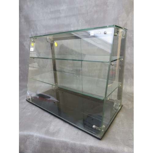 26 - A PLATE GLASS TWO SHELF SHOP DISPLAY CABINET WITH SLOPING FRONT, sliding doors to back, H 46 cm, W 6... 