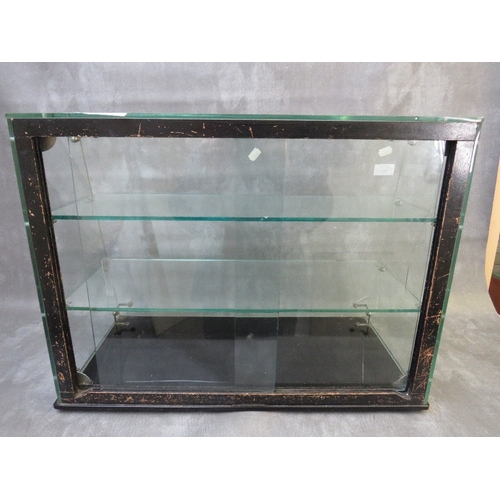 26 - A PLATE GLASS TWO SHELF SHOP DISPLAY CABINET WITH SLOPING FRONT, sliding doors to back, H 46 cm, W 6... 