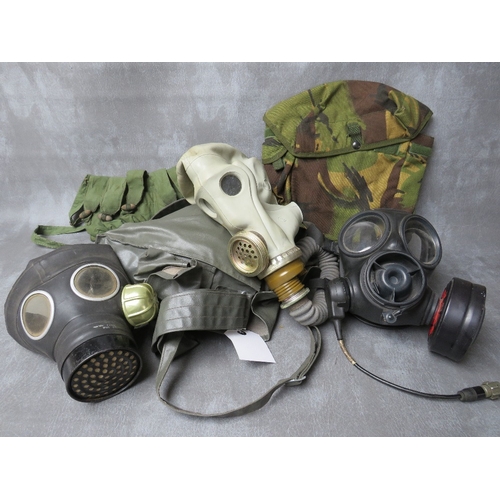 64 - THREE ASSORTED GAS MASKS, a British example date 1954, a Russian type with gloves in pouch dated 198... 