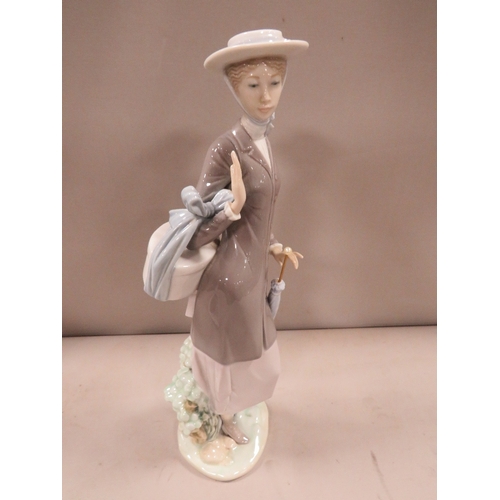 301 - A Lladro figure of a lady holding a basket and a parasol