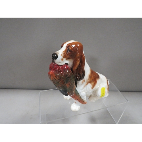 325 - A Royal Doulton figure of a liver and white spaniel carrying a pheasant HN1028 A/F - tail has been r... 