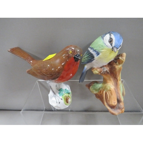 336 - A Royal Doulton seated Ginger cat together with three assorted bird figures one A/F