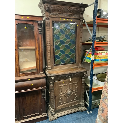 734 - A Victorian oak glazed and leaded carved cupboard with lion mask detail H 235 cm W 92 cm