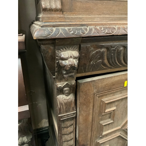 734 - A Victorian oak glazed and leaded carved cupboard with lion mask detail H 235 cm W 92 cm