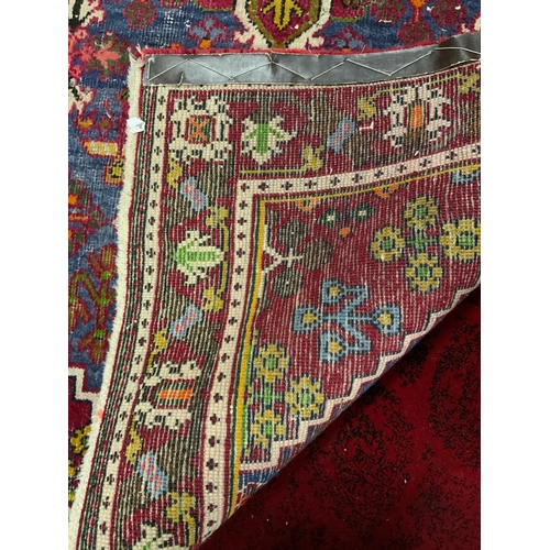 749 - An Eastern red woollen rug 150 x 105 cm