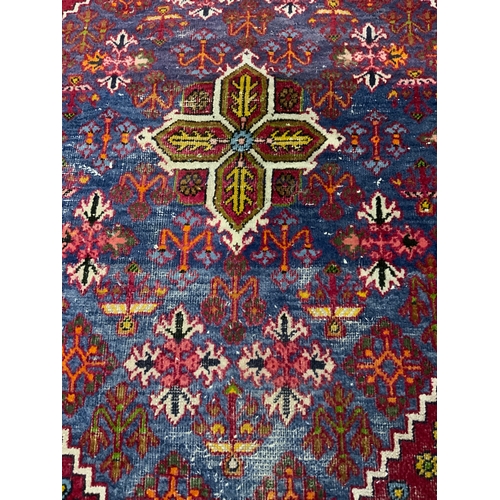 749 - An Eastern red woollen rug 150 x 105 cm