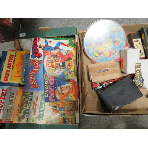 142 - Two trays of vintage games and annuals to include a vintage Dan Dare planet gun in original box