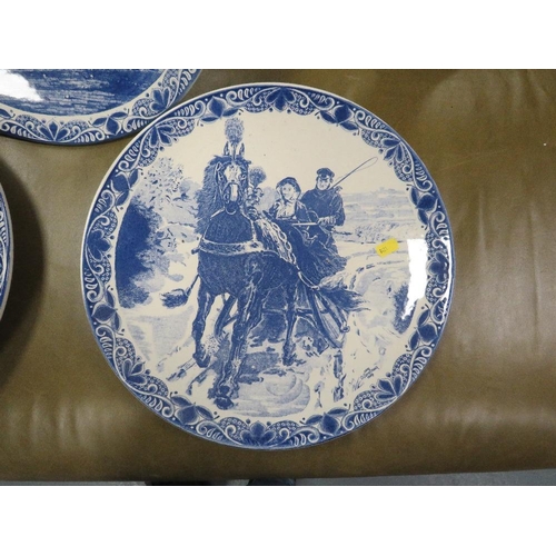 53 - Three Delfts Blauw hand painted equestrian themed chargers together with a tray of blue and white wa... 