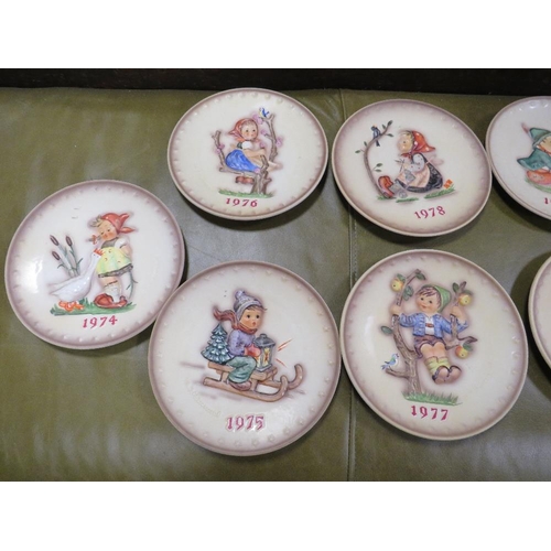 70 - A tray of Goebel year plates together with seven Goebel year bells