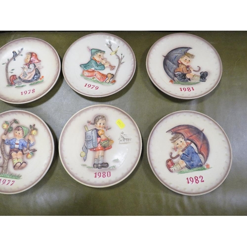 70 - A tray of Goebel year plates together with seven Goebel year bells