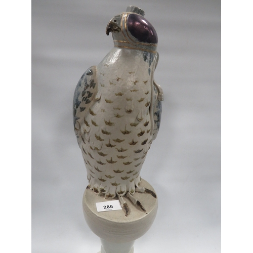 286 - An unusual table lamp in the form of a hooded falcon on stand