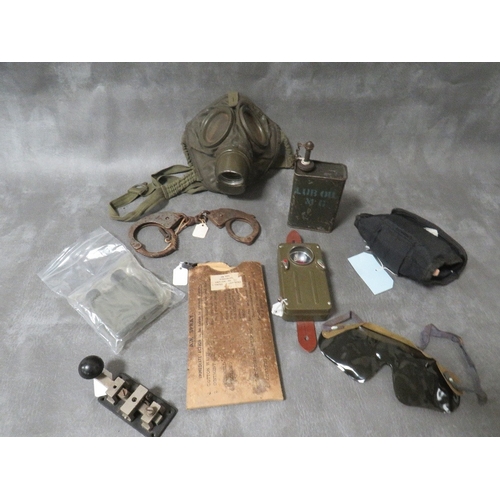 315 - A BOX OF MILITARY INTEREST COLLECTIBLES, to include a gas mask, a Vickers machine gun oil bottle, mo... 