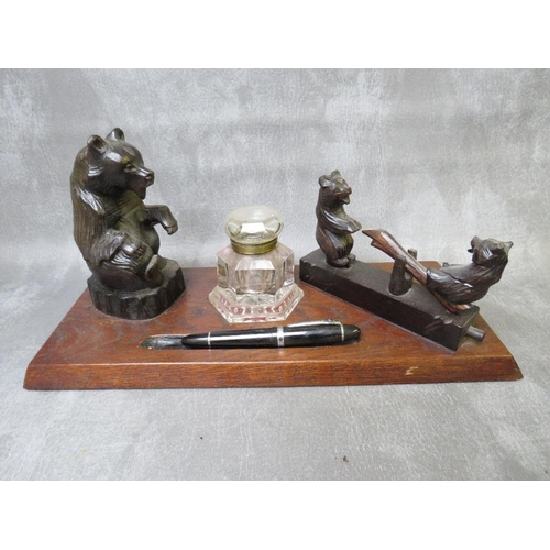 1086 - AN EARLY 20TH CENTURY BLACK FOREST STYLE INKSTAND, modelled with a seated bear, central heavy glass ... 