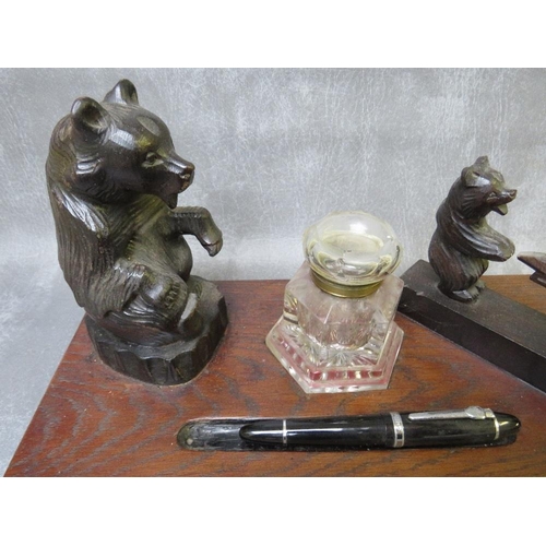 1086 - AN EARLY 20TH CENTURY BLACK FOREST STYLE INKSTAND, modelled with a seated bear, central heavy glass ... 